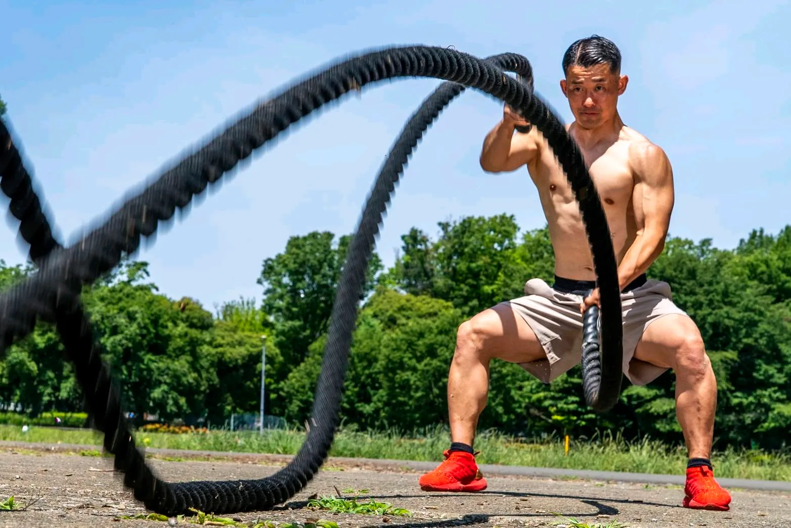 屋外でバトルロープを使ってトレーニングする、出張パーソナルトレーナーのミッツ隊長
